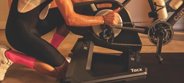 Mężczyzna montuje łańcuch roweru na trenażerze Tacx Neo 3M