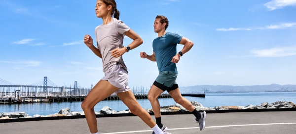 Mężczyzna z kobietą biegną po ulicy z zegarkami Garmin na ręce